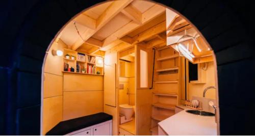 - une petite cuisine avec une arche dans une petite maison dans l'établissement Le pigeonnier - TinyHouse en plein centre de Liège, à Liège