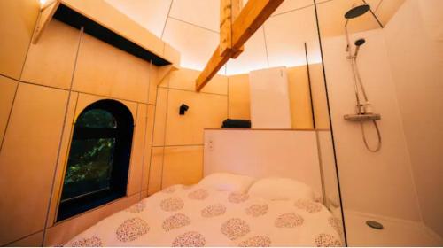 un piccolo letto in una casetta con finestra di Le pigeonnier - TinyHouse en plein centre de Liège a Liegi