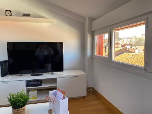 a living room with a flat screen tv and a window at Vivienda turística Los Tejados in Soria