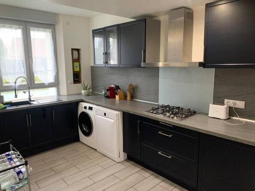 a kitchen with a washing machine and a washer at Maison 3 chambres 