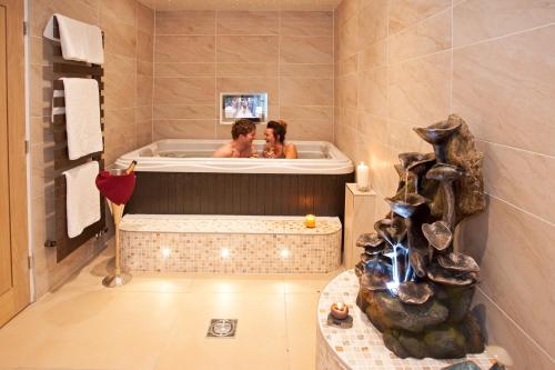 a man and woman in a bath tub at Windermere Boutique Hotel Spa Suites & Hot Tubs in Windermere