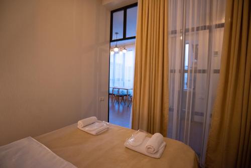 1 dormitorio con 1 cama con 2 toallas en LUXURY APARTMENT IN OLD TBILISI WITH TERRACe en Tiflis