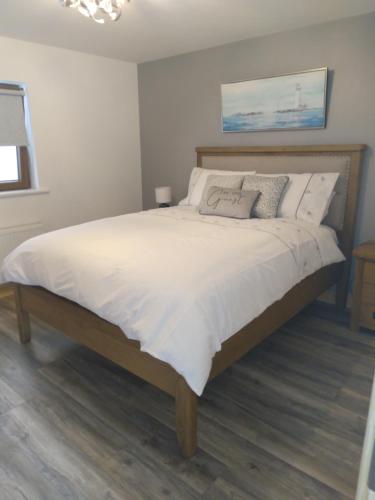a bedroom with a large bed with white sheets and pillows at The Dingle Galley in Dingle