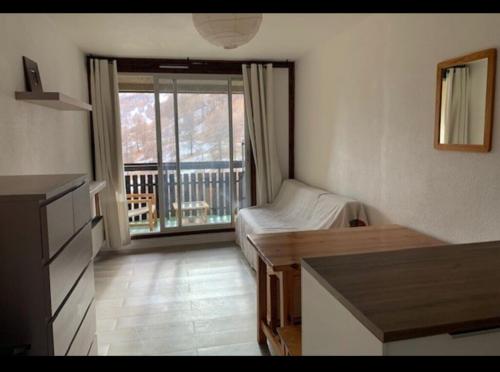 Habitación con 1 dormitorio con 1 cama y balcón. en L ANTARES residence les etoiles la foux d allos joli studio 4 couchages en La Foux