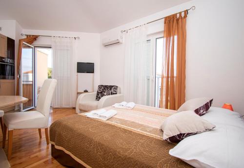 a bedroom with a large bed and a table and chairs at LotusApart in Premantura