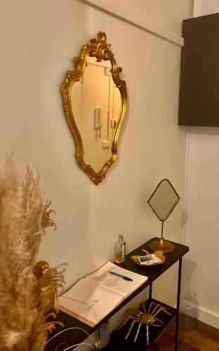 a mirror on a wall next to a table with a laptop at Les Petites Fécampoises by Mathilde in Fécamp