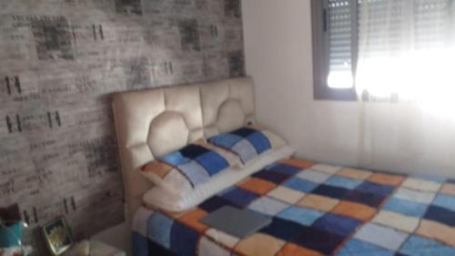 a bedroom with a white bed with a checkeredkered at Appartement au calme hors du bruit de Casablanca à Bouskoura in Bouskoura