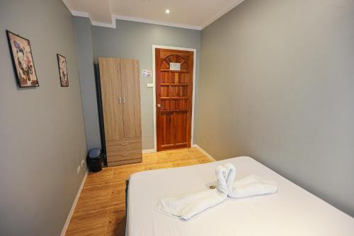 a bedroom with a bed with a white blanket at Kingswick Residences & Lodge in Dumaguete