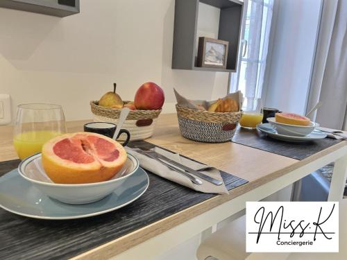 - une table avec un bol de fruits et des paniers de fruits dans l'établissement "Les Angelots", à Mâcon