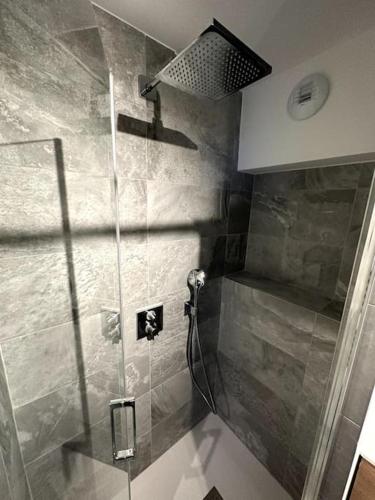 une douche avec une porte vitrée dans une salle de bain dans l'établissement T3 neuf Courchevel 1650 Domaine de l’Ariondaz, à Courchevel