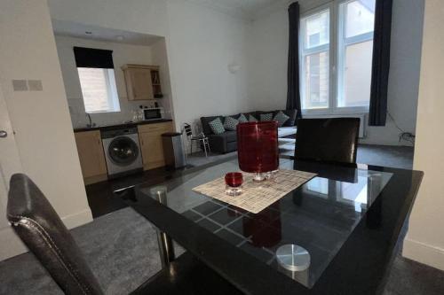 a dining table with two glasses on it in a living room at Regent Apartments - Glasgow City Centre in Glasgow