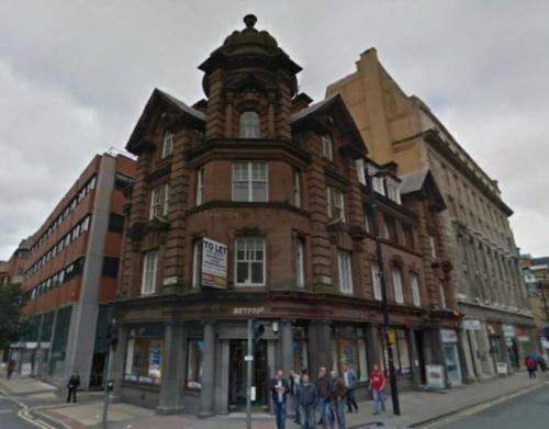 a large brick building on the corner of a street at Regent Apartments - Glasgow City Centre in Glasgow