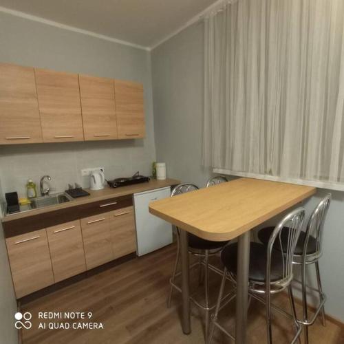 una cocina con mesa de madera y sillas. en Ideal for family and older pers., en Riga