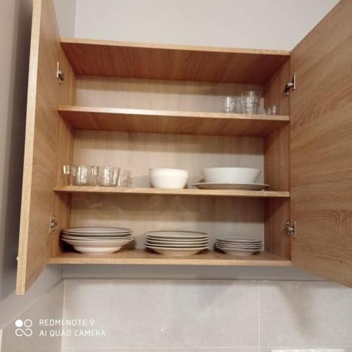 a wooden cabinet with plates and bowls on it at Simana 3A Ideal for family and older pers in Rīga