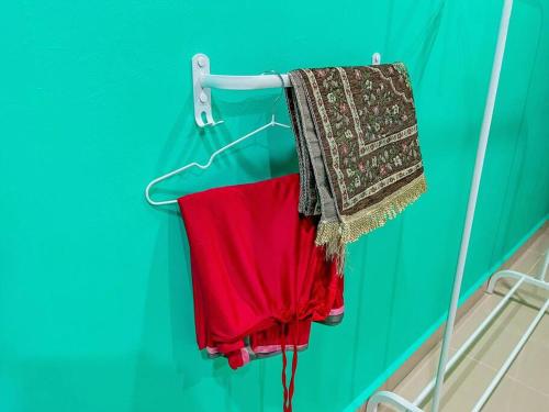 a red shirt is hanging on a rack at Dj Impiana Homestay @ Bukit Keluang Besut in Kampung Raja