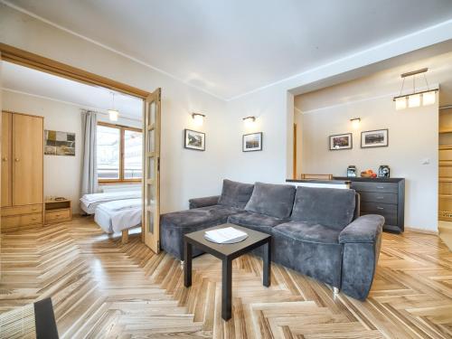 a living room with a couch and a bed at VisitZakopane - Lemon Apartment in Zakopane
