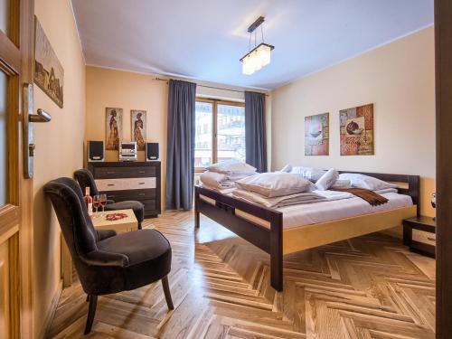 a bedroom with a bed and a chair at VisitZakopane - Lemon Apartment in Zakopane