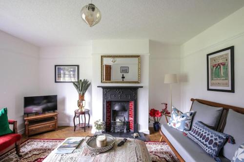 a living room with a couch and a fireplace at Duke of York Cottage, Port Sunlight - Stanley-Stays in Wirral