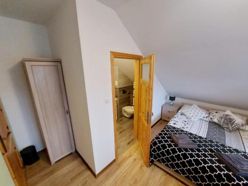 a small bedroom with a bed and a mirror at Pokoje gościnne "Trudziń-SKI" in Świeradów-Zdrój