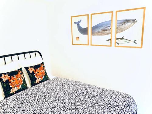 - une chambre avec un lit et deux photos encadrées d'une baleine dans l'établissement Superbe 2 pièces - 4 couchages - Clim - Parking - Piscine résidence, à Théoule-sur-Mer