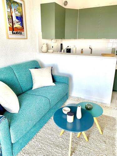 un salon avec un canapé bleu et une table dans l'établissement Superbe 2 pièces - 4 couchages - Clim - Parking - Piscine résidence, à Théoule-sur-Mer