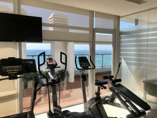 a gym with two exercise bikes and a television at deptomardel_playa in Mar del Plata