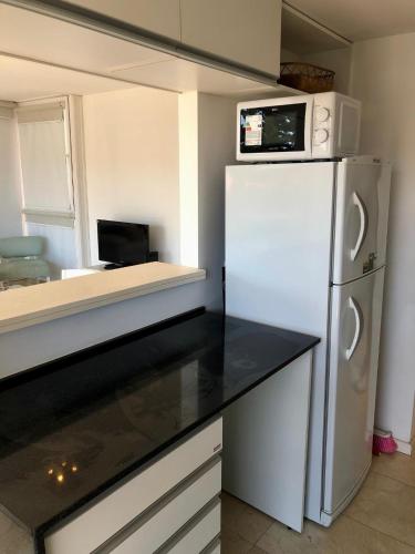 a kitchen with a white refrigerator and a microwave at deptomardel_playa in Mar del Plata