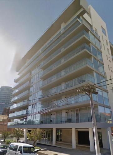 a large building with a car parked in front of it at deptomardel_playa in Mar del Plata