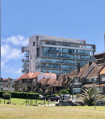 a large building in front of a group of houses at deptomardel_playa in Mar del Plata