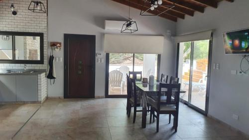 eine Küche und ein Esszimmer mit Tisch und Stühlen in der Unterkunft Cabañas LOS BEDUINOS in Mar de las Pampas