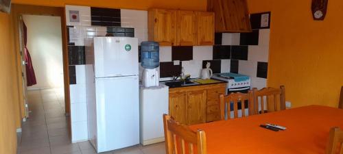 Una cocina con un refrigerador blanco y una mesa. en NOGOLI EL REMANSO, en San Luis