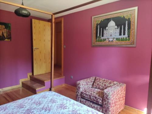 - une chambre avec une chaise et une photo du taj mahal dans l'établissement Casa con encanto en el campo, à Pontevedra