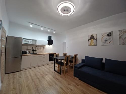 uma sala de estar com um sofá azul e uma cozinha em Paderewskiego Old Town Apartaments em Cracóvia