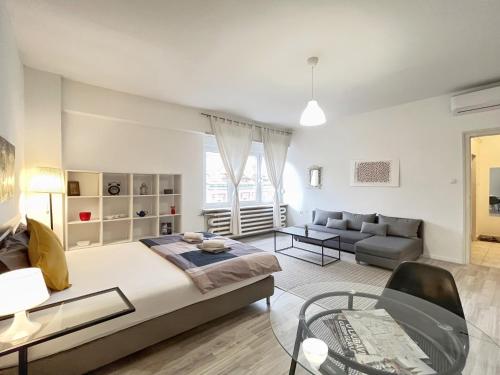 a bedroom with a bed and a couch and a table at Agape Main Square Apartment in Zagreb