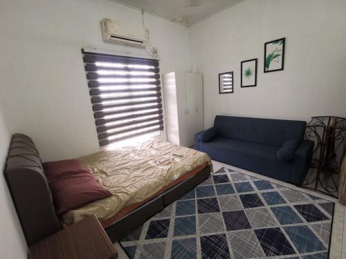 ein Wohnzimmer mit einem Bett und einem Sofa in der Unterkunft NASYA HOMESTAY BANDAR ENSTEK in Kampong Chinchang