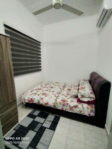 ein Schlafzimmer mit einem Bett in einem Zimmer in der Unterkunft NASYA HOMESTAY BANDAR ENSTEK in Kampong Chinchang