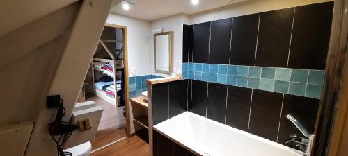 a bathroom with a sink and a blue tile wall at Hôtel spa Transhumance & cie in Bedous