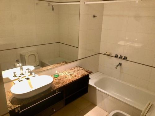 a bathroom with a sink and a tub and a toilet at deptomardel_playa in Mar del Plata