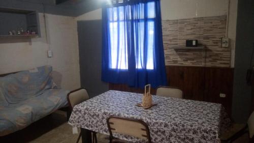 comedor con mesa y cortina azul en ESTABLECIMIENTO LA GEORGI en Luján de Cuyo