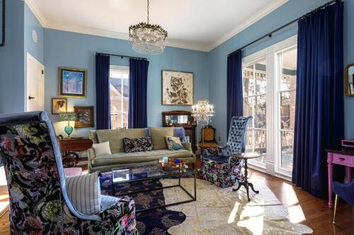 a living room with blue walls and a couch and chairs at Celestine Bed and Breakfast in Pensacola