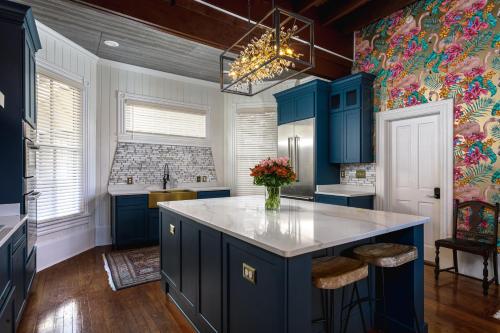 a kitchen with blue cabinets and a vase of flowers at Celestine Bed and Breakfast in Pensacola