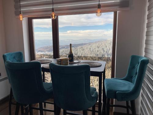 - une table et des chaises devant une fenêtre avec vue dans l'établissement Luxury Sunny Hill, à Kopaonik