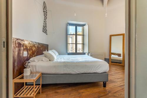 1 dormitorio con 1 cama grande y espejo en TAG Guest House, en Viterbo