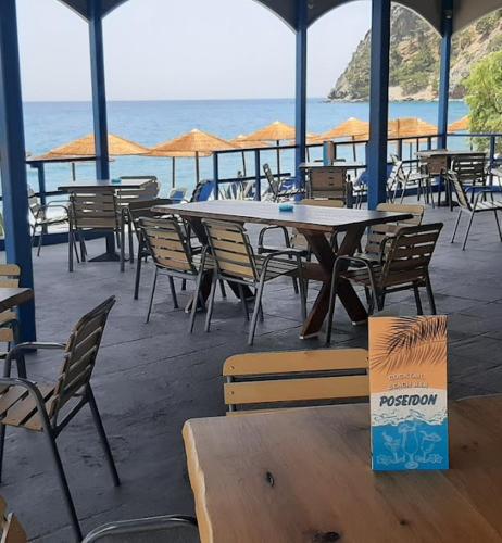 a restaurant with tables and chairs and the ocean at Hotel Agia Roumeli by the SEA in Agia Roumeli