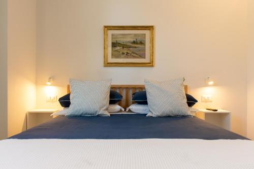 a bedroom with a bed with two blue and white pillows at Suite Apartments - Corso51 in Rimini