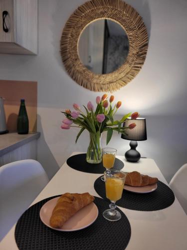 - une table avec deux assiettes de pâtisseries et un miroir dans l'établissement Apartament Helena, à Międzyzdroje