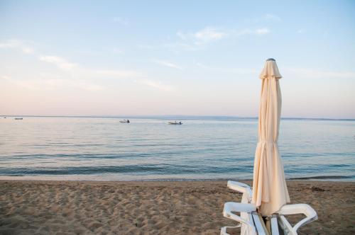 a beach umbrella and two chairs on the beach at Alexger Gerakini Beach house view in Gerakini