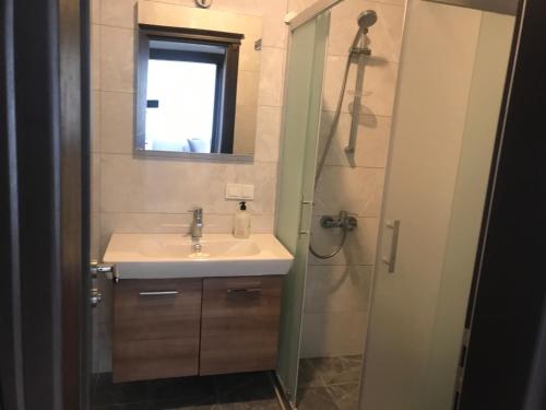 ein Bad mit einem Waschbecken, einem Spiegel und einer Dusche in der Unterkunft Golden Lake Aparts in Koycegiz