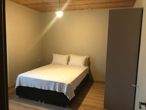 1 dormitorio con 1 cama con sábanas y almohadas blancas en Golden Lake Aparts, en Koycegiz
