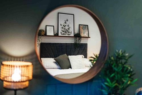 a mirror in a room with a bed with pillows at Boho Loft in Somerset - Private Parking in Radstock